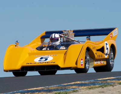 Chris McAllister showing plenty of daylight under his McLaren M8F. Is it any wonder that this otherwise dominating Can-Am machine suffered the occasional blow-over in its heyday. [Sports Car Digest image by Dennis Gray]